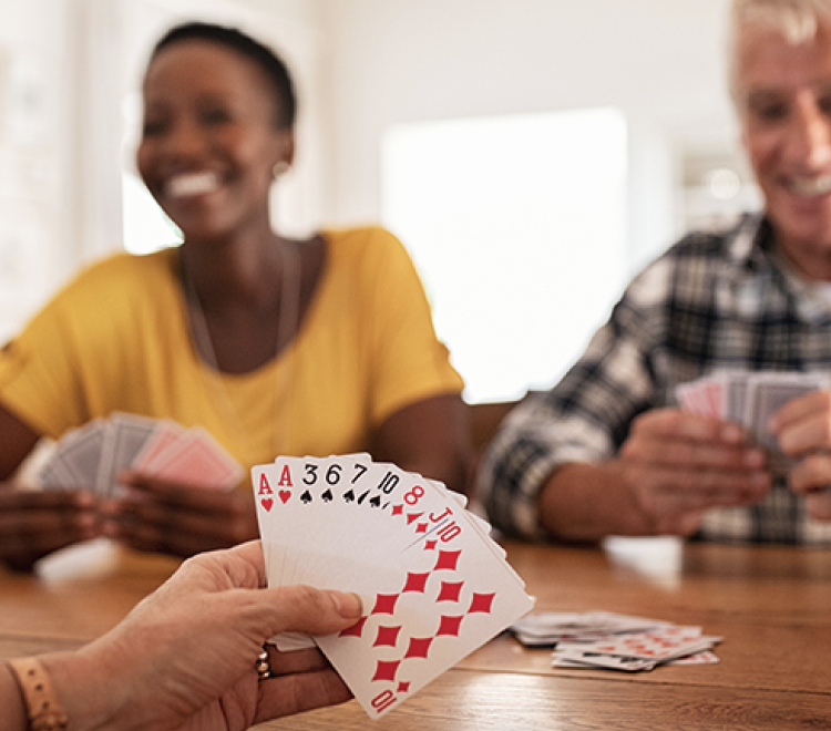 Three people playing cards at the table